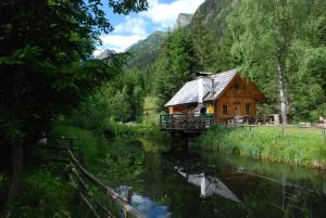 une cabane en bois au milieu d'une rivière dans l'établissement Ferienhaus Christine Bauer, à Hintergöriach