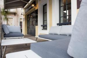 a patio with two blue couches and a table at Hôtel Restaurant Corto Maltese in Le Palais