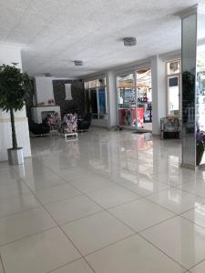 a lobby with a white tiled floor and chairs at Kalkan Dream Hotel in Kalkan