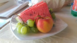 a plate of fruit with apples and grapes on a table at Hotel Casa Gerardo in Sant'Angelo D'Ischia
