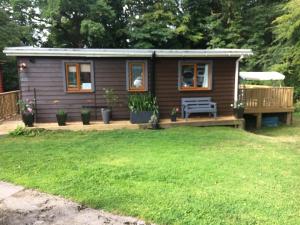 a tiny house with a bench in a yard at Scarlett Cabin Glan Gwna in Caernarfon