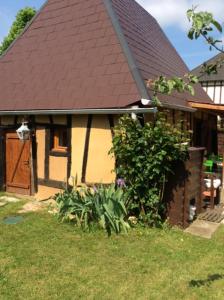 Collandres-Quincarnon的住宿－Ancien Relais de Poste，一间棕色屋顶和庭院的房子
