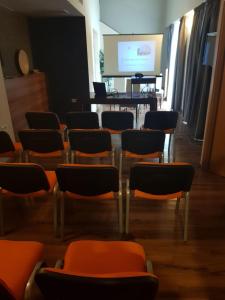 a room with chairs and a table and a screen at Hotel Hemingway Residence in Bucharest