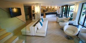 a living room with white furniture and a television at Hotel Monica in Riccione