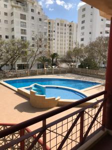 een balkon met uitzicht op een zwembad bij Edificio Fragata A in Armação de Pêra