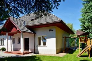 a small house with a black roof at Willa u Basi in Miłków