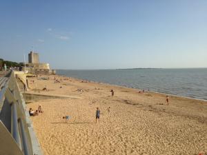 een groep mensen op een strand vlakbij het water bij Le Cottage in Rochefort