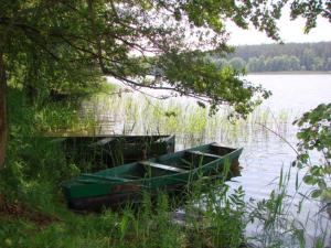 two boats parked next to a bridge on a lake at Raj z haczykiem in Grzmięca