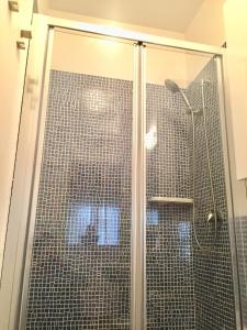 y baño con ducha y puerta de cristal. en Apartment "da Max", en Palermo