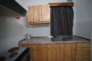 a small kitchen with a sink and wooden cabinets at Cardor Holiday Complex in St Paul's Bay