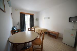 una camera con tavolo e sedie e una cucina di Cardor Holiday Complex a San Pawl il-Baħar