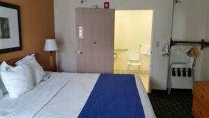 a hotel room with a large bed and a door at Days Inn by Wyndham Chattanooga/Hamilton Place in Chattanooga +10 photos