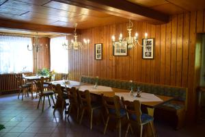 una sala da pranzo con pareti e tavoli in legno e sedie di Gasthof Uttewalde a Uttewalde