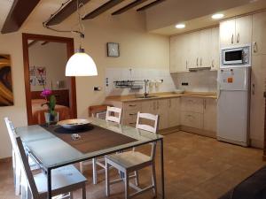 a kitchen with a table and chairs and a refrigerator at Les Muntades in Jorba