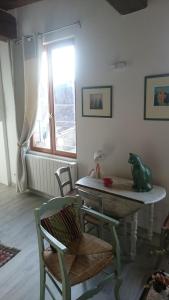 Zimmer mit einem Tisch, Stühlen und einem Fenster in der Unterkunft Rémalard appartement in Rémalard
