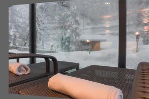 a person laying on a chair in the snow at Hotel Adler in Nova Levante