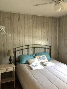 1 dormitorio con 1 cama con almohadas azules en Little Ted's Cottages, en Marblehead