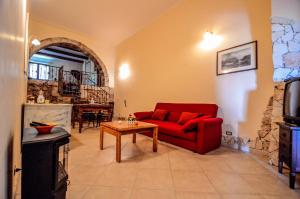 a living room with a red couch and a table at La Vecchia Torre in Giarre