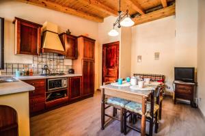 a kitchen with a table with chairs and a kitchen with a stove at La Vecchia Torre in Giarre