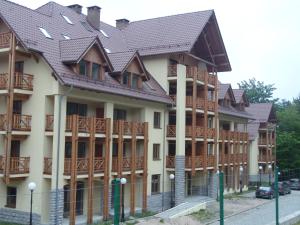 a building with wooden balconies and a roof at Apartament Ilona in Szklarska Poręba