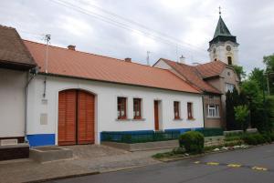 ein weißes Gebäude mit einem Uhrturm und einer Kirche in der Unterkunft U Stařenky in Dolní Bojanovice