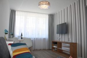 a living room with a table and a television in it at Centrum in Szczecin