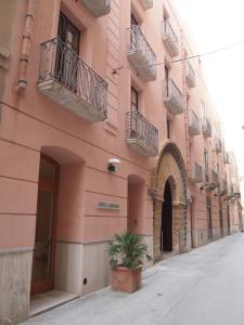 a pink building with a potted plant in front of it at Hotel Moderno in Trapani