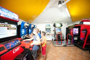 a group of children playing a video game in a arcade at Camping Torre Castiglione in Torre Lapillo