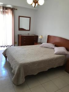 a bedroom with a large bed and a mirror at Edificio Caique C in Armação de Pêra
