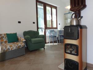 a living room with a stove in the middle of a room at Casetta tra gli Ulivi vicina al Mare in Giustenice +18 photos