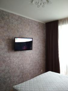 a bedroom with a flat screen tv on the wall at New Apartment with 2 Isolated Bedrooms in Lviv