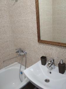 a bathroom with a white sink and a mirror at New Apartment with 2 Isolated Bedrooms in Lviv