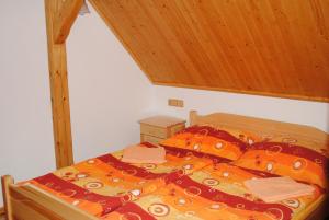 1 cama con edredón y almohadas en Roubenka-Mila, en Ostružná