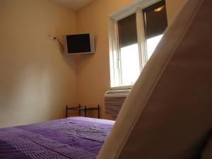 ein Schlafzimmer mit einem Bett und einem Fenster in der Unterkunft The Rex Hotel Jazz & Blues Bar in Toronto