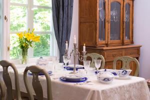 Una mesa de comedor con un mantel blanco y sillas. en Koivulan Kartano, en Lohja