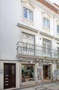 un bâtiment blanc avec un balcon au-dessus dans l'établissement Cantinho do SAL Apartamento T3, à Aveiro