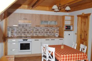 una cocina con armarios blancos y una mesa con mantel. en Roubenka-Mila, en Ostružná