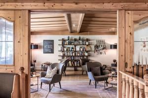 una biblioteca con sillas y estanterías en un edificio en Hotel Seehof Nature Retreat en Naz-Sciaves