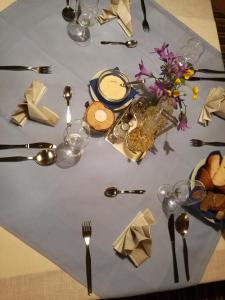a table with a table cloth with forks and spoons at Residence Terentis in Terento