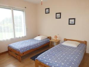 two twin beds in a room with a window at lambezen, vue mer in Camaret-sur-Mer