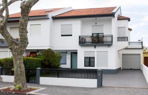a white house with a balcony and a fence at Mountain and Sea in Ribeira Grande