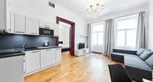 a kitchen and a living room with a couch at Apartments Zborovska in Prague