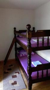 een kamer met paarse stapelbedden met paarse kussens bij Boro apartment in Kaštela