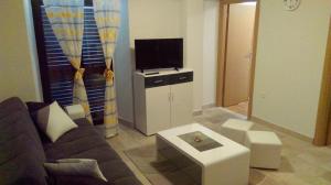 een woonkamer met een bank en een tv bij Boro apartment in Kaštela