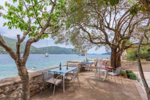 a group of tables and chairs next to the water at Apartment Sea Dream in Ston