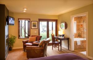 a living room with a chair and a desk and a tub at Brewery Gulch Inn & Spa in Mendocino