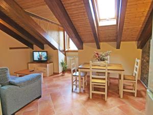 a dining room with a table and chairs and a television at Casa Fes Autural in Aínsa