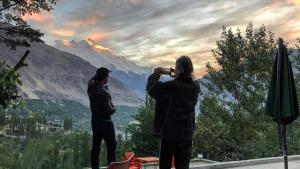 zwei Personen, die ein Foto von einem Berg machen in der Unterkunft Baltit Heritage Inn in Hunza + 7 Fotos