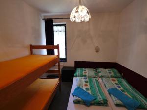 ハルラホフにあるApartmán Chlupáčのベッドとシャンデリア付きの小さなベッドルーム1室