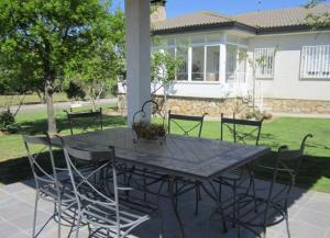 une table et des chaises devant une maison dans l'établissement Tres Hermanos CON PISCINA PRIVADA, à Pelabravo